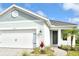 Charming exterior showing a two-car garage, elegant front door, and lush landscaping at 12570 Brookgreen St, Venice, FL 34293