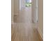 Hallway with wood-look tile floors leading to a doorway and window to the lanai at 12570 Brookgreen St, Venice, FL 34293