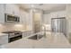 Close-up of kitchen island with quartz countertop, stainless steel sink, and modern fixtures at 12570 Brookgreen St, Venice, FL 34293