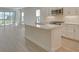 Open kitchen showcasing white cabinetry, stainless steel appliances, and a large island with counter seating at 12570 Brookgreen St, Venice, FL 34293