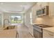 Stylish kitchen featuring stainless steel appliances, quartz countertops, and a view of the lanai at 12570 Brookgreen St, Venice, FL 34293