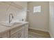 Bright laundry room features a utility sink, white cabinets, a chrome faucet, and a wire rack at 12570 Brookgreen St, Venice, FL 34293