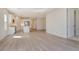 Open-concept living room featuring wood-look tile floors and seamless flow into the kitchen at 12570 Brookgreen St, Venice, FL 34293