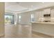 Open-concept living room with wood floors and a kitchen featuring an island and modern appliances at 12570 Brookgreen St, Venice, FL 34293