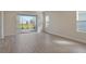 Bright living room featuring wood-look tile floors and sliding glass doors to the screened lanai at 12570 Brookgreen St, Venice, FL 34293