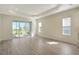 Bright living room with wood-look tile floors, sliding glass doors to the lanai, and recessed lighting at 12570 Brookgreen St, Venice, FL 34293