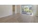 Living room with wood-look tile floors and sliding glass doors to the lanai with a view at 12570 Brookgreen St, Venice, FL 34293