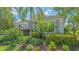 Close-up of a home's facade with a meticulously maintained garden and a charming coach light at 14350 Stirling Dr, Lakewood Ranch, FL 34202