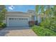 Attractive home featuring a two-car garage, brick driveway, and professionally designed landscaping at 14350 Stirling Dr, Lakewood Ranch, FL 34202