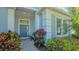 Welcoming home entrance with a stylish front door, elegant sidelights, and beautiful landscaping at 14350 Stirling Dr, Lakewood Ranch, FL 34202
