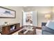 A cozy living room with an ocean-themed art piece, comfortable seating, and an open doorway invites relaxation and conversation at 14350 Stirling Dr, Lakewood Ranch, FL 34202