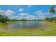 Scenic view of the pond surrounded by well-manicured lawns and bright blue skies at 14350 Stirling Dr, Lakewood Ranch, FL 34202