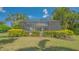 The house features a screened-in pool area surrounded by lush landscaping and palm trees at 14350 Stirling Dr, Lakewood Ranch, FL 34202