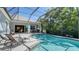 Backyard featuring a screened-in pool, patio seating and mature trees at 14350 Stirling Dr, Lakewood Ranch, FL 34202