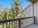 Balcony view showcasing lush tropical surroundings, the building's architectural details, and blue sky at 1493 Landings Lake Dr # 32, Sarasota, FL 34231