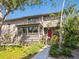 Inviting home exterior with a red front door, porch and manicured front yard at 1493 Gulf Of Mexico Dr #312, Longboat Key, FL at 1493 Landings Lake Dr # 32, Sarasota, FL 34231