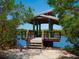 Tranquil waterfront gazebo with wooden steps, seating, and a bicycle nearby offer a place to relax at 1493 Landings Lake Dr # 32, Sarasota, FL 34231