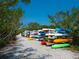 Colorful kayaks are stacked on racks near a gravel path, providing outdoor recreational opportunities at 1493 Landings Lake Dr # 32, Sarasota, FL 34231