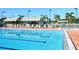 Sparkling blue community swimming pool featuring lounge chairs and mature trees, perfect for relaxation at 1493 Landings Lake Dr # 32, Sarasota, FL 34231