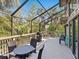 Spacious screened porch with outdoor dining set, grill and wooded backdrop at 1493 Landings Lake Dr # 32, Sarasota, FL 34231