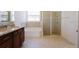 Luxurious bathroom with dual vanities, soaking tub, glass-enclosed shower, and elegant tile flooring at 15543 Trinity Fall Way, Bradenton, FL 34212