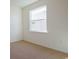 A bright bedroom with neutral carpet and a large window for ample natural light at 15543 Trinity Fall Way, Bradenton, FL 34212