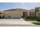 Inviting single-story home featuring a three-car garage, well-maintained lawn, and desirable curb appeal at 15543 Trinity Fall Way, Bradenton, FL 34212