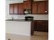 A kitchen showcases rich wooden cabinetry, modern appliances, and a center island with a breakfast bar at 15543 Trinity Fall Way, Bradenton, FL 34212