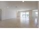 Bright and airy living room featuring neutral tile flooring and expansive sliding glass doors offering backyard views at 15543 Trinity Fall Way, Bradenton, FL 34212