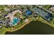 Aerial view of community pool, tennis, and basketball courts by a serene lake at 1586 Dorgali Dr, Sarasota, FL 34238