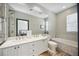 Bathroom featuring double vanity, a soaking tub, and a large mirror with tiled accents around the fixtures at 1586 Dorgali Dr, Sarasota, FL 34238