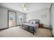A modern bedroom featuring a neutral palette, a ceiling fan, and a door that leads to a balcony area at 1586 Dorgali Dr, Sarasota, FL 34238