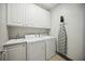 Functional laundry room featuring a utility sink, a washer and dryer, and storage cabinets at 1586 Dorgali Dr, Sarasota, FL 34238