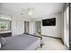 A bedroom with a ceiling fan, large window, wall-mounted TV and access to the en-suite bathroom at 1586 Dorgali Dr, Sarasota, FL 34238