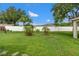 Expansive backyard with lush green grass, tropical plants and a secure white fence at 18106 Canal Pointe St, Tampa, FL 33647