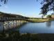 Scenic view of a lush golf course with a wooden bridge over a lake, framed by trees and a blue sky at 18106 Canal Pointe St, Tampa, FL 33647