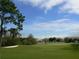 Lush green golf course featuring a sand trap and distant community homes at 18106 Canal Pointe St, Tampa, FL 33647