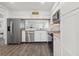 Stylish kitchen featuring stainless steel appliances, white cabinets, and modern wood flooring at 18106 Canal Pointe St, Tampa, FL 33647