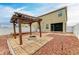View of the backyard featuring a pergola, fire pit area, and paved walkways at 1912 Hawks View Dr, Ruskin, FL 33570