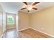 The bedroom offers wood-look floors, a ceiling fan, and a window with natural light at 1912 Hawks View Dr, Ruskin, FL 33570