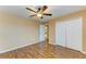 This bedroom boasts wood-look floors, a ceiling fan, and a closet with white doors at 1912 Hawks View Dr, Ruskin, FL 33570
