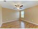 Bedroom features wood-look floors, ceiling fan, and window with natural light at 1912 Hawks View Dr, Ruskin, FL 33570