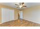 Bedroom with light walls, ceiling fan, wood flooring, and closet storage at 1912 Hawks View Dr, Ruskin, FL 33570