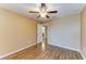 Bright bedroom featuring wood-look floors, ceiling fan, and an interior door to bathroom at 1912 Hawks View Dr, Ruskin, FL 33570