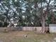 Large backyard with a wooden fence, mature trees, and a shed at 2035 Vinson Ave, Sarasota, FL 34232