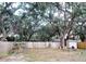 Large backyard with a wooden fence, mature trees, and a shed at 2035 Vinson Ave, Sarasota, FL 34232