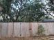 This backyard features a wooden fence with a gate to the alley and tropical vegetation at 2035 Vinson Ave, Sarasota, FL 34232