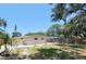 Fenced backyard with lush trees and a spacious area that offers great potential for landscaping at 2035 Vinson Ave, Sarasota, FL 34232