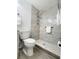 Updated bathroom showcasing a tiled shower with built-in shelving, grab bar, and modern fixtures at 2035 Vinson Ave, Sarasota, FL 34232