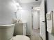 Bright bathroom showcasing a clean design with a vanity, round mirror, and access to additional rooms at 2035 Vinson Ave, Sarasota, FL 34232